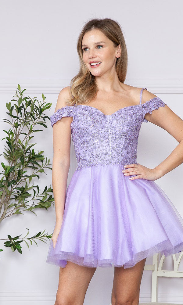 A woman models the Lace-Up Off-Shoulder Short Babydoll Hoco Dress9234 in lilac, featuring lace and tulle. She stands indoors near a potted plant, one hand on her hip.